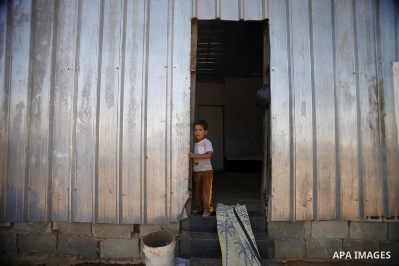 A Palestinian boy stands at the entrance of his family's housing container in the east Jerusalem village of al-Zaeem, Sept. 11, 2013. Israeli bulldozers demolished on Wednesday morning 20 housing containers belonging to...