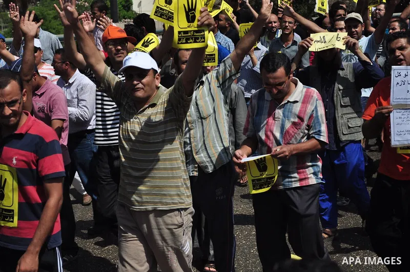 Supporters of ousted Egyptian president Mohamed Morsi hold posters with a four finger symbol, known as "Rabaa", which means four in Arabic during a protest named "Friday of Loyalty to the Blood of the Martyrs" against th...