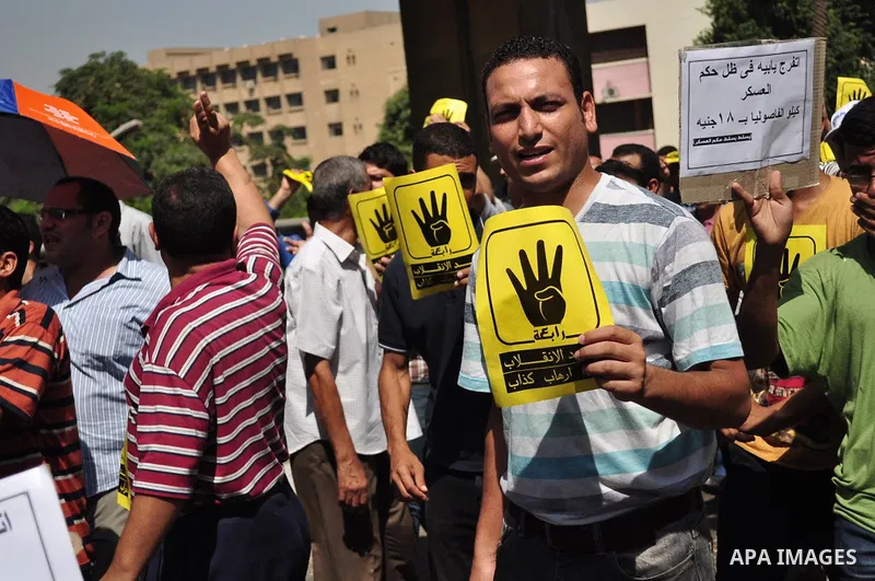 Supporters of ousted Egyptian president Mohamed Morsi hold posters with a four finger symbol, known as "Rabaa", which means four in Arabic during a protest named "Friday of Loyalty to the Blood of the Martyrs" against th...