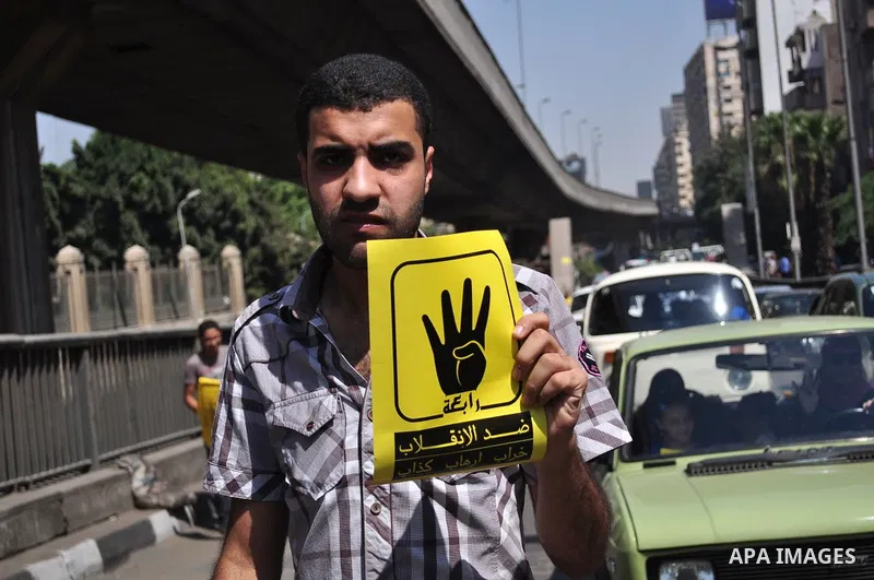 Supporters of ousted Egyptian president Mohamed Morsi hold posters with a four finger symbol, known as "Rabaa", which means four in Arabic during a protest named "Friday of Loyalty to the Blood of the Martyrs" against th...