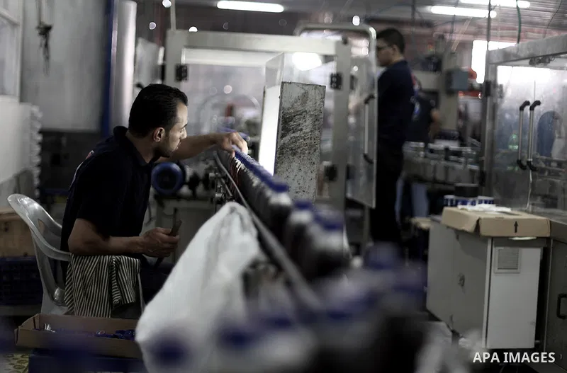 Palestinians work at al-Madina factory, a local soft drinks production line, in Gaza City on Sept. 15, 2013. The production line threatened to stop working since the crackdown campaign of Egyptian security forces on smug...