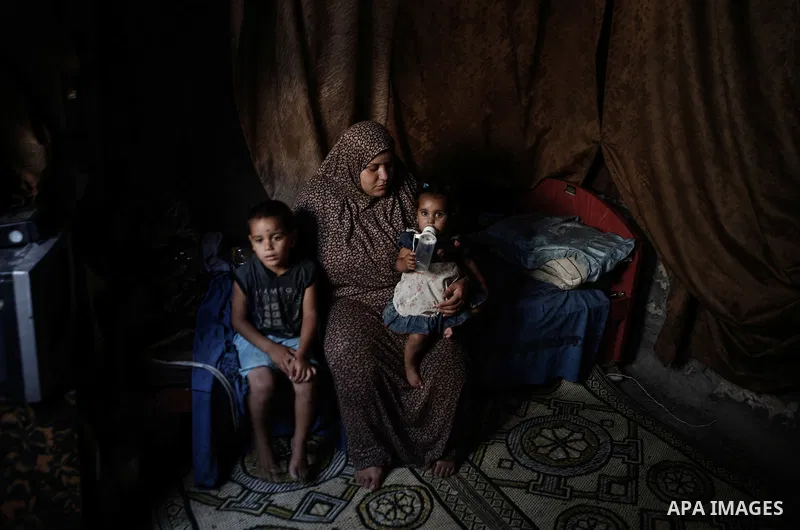 A Palestinian woman sits with her kids at their home in a poverty-stricken quarter of al-Zaytoon in Gaza City on Sept. 17, 2013. Reports said that an increasing number of Gaza families are reportedly falling further into...