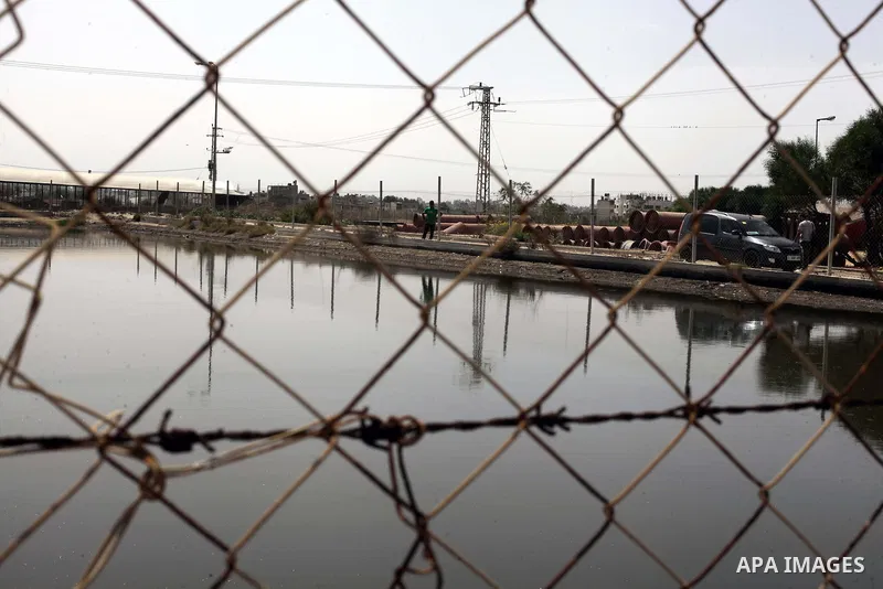 A Palestinian man walks next to the sewage water basins near the Bedouin Village in the northern Gaza Strip, Sept. 19, 2013. The area is threatened with an environmental and humanitarian disaster due to the accumulation...