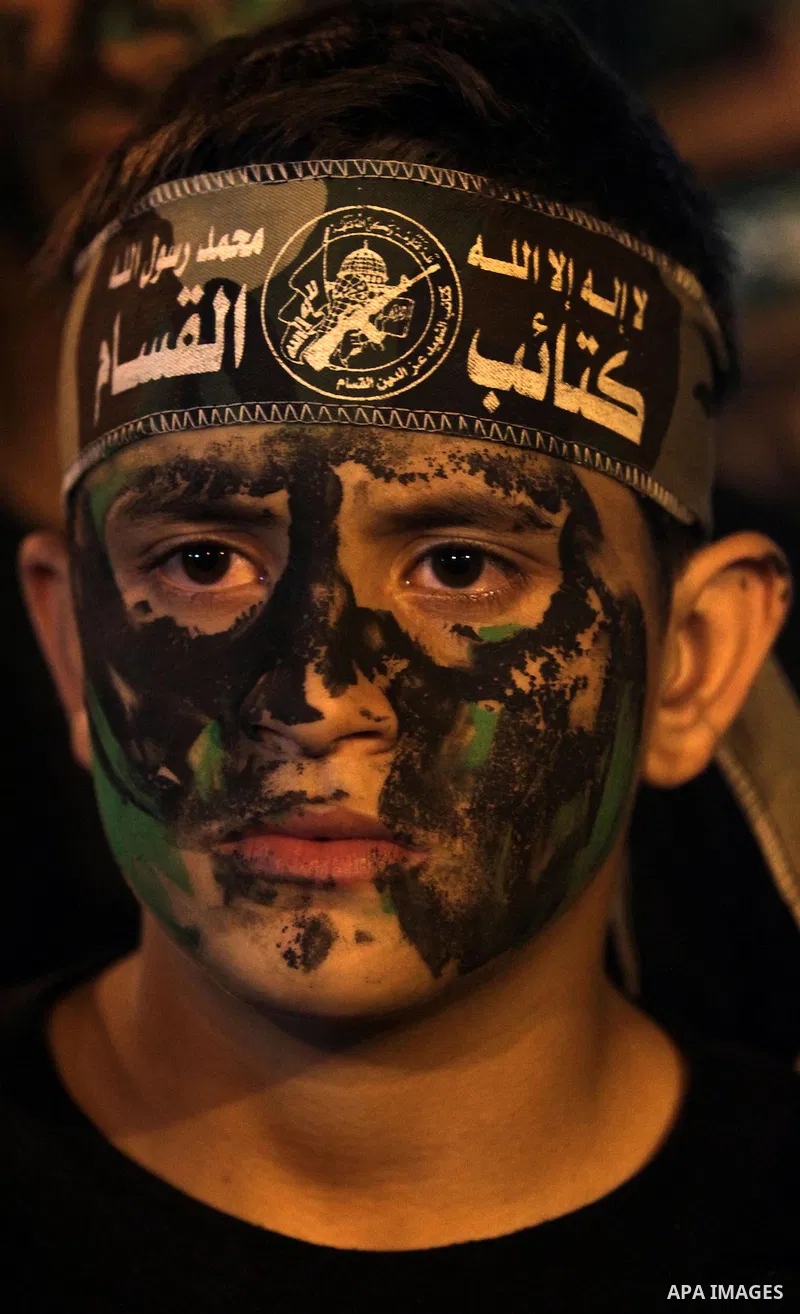 A Palestinian boy, wearing a head band reading in Arabic 'al-Qassam Brigades' during a rally marking 13th anniversary of the so-called Al-Aqsa uprising or 'Second Intifada', in Gaza City, 26 September 2013. Palestinians...