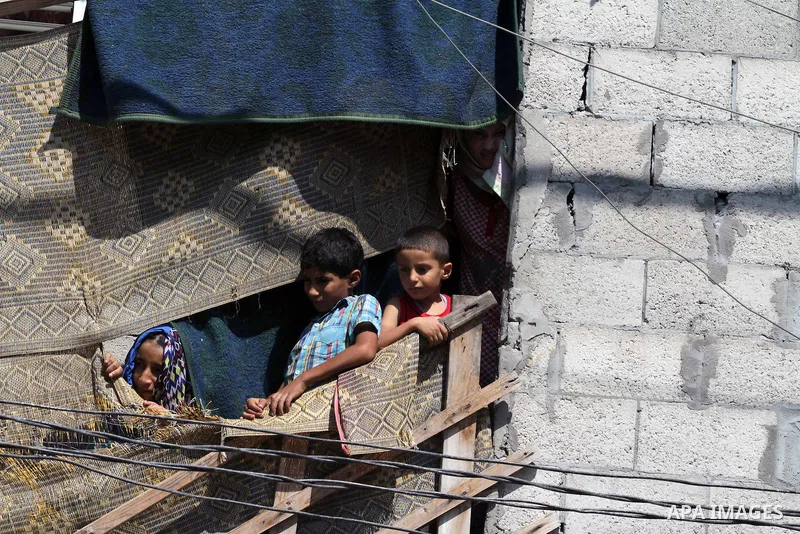 Palestinian children watch, as Hamas supporters take part in a protest to show solidarity with Al-Aqsa mosque after Friday prayers in the central Gaza Strip September 27, 2013. The words on the right read, "Oslo is the n...