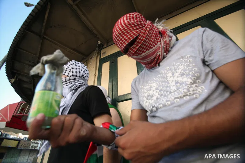 A Palestinian protester prepares a molotov cocktail during clashes with Israeli security forces in the West Bank city of Hebron September 27, 2013. Israeli police clashed with Palestinian protesters in Jerusalem's Old Ci...