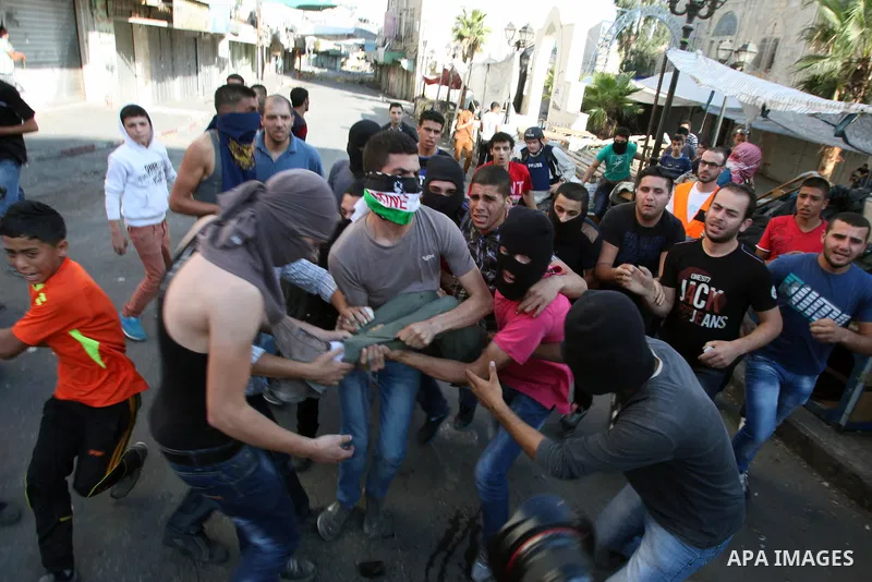 Palestinians help a wounded protester during clashes with Israeli security forces in the West Bank city of Hebron September 27, 2013. Israeli police clashed with Palestinian protesters in Jerusalem's Old City, the Gaza S...
