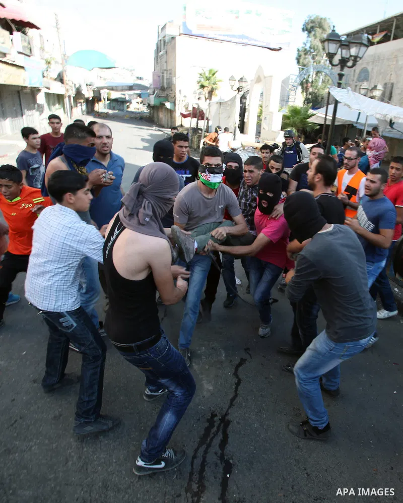 Palestinians help a wounded protester during clashes with Israeli security forces in the West Bank city of Hebron September 27, 2013. Israeli police clashed with Palestinian protesters in Jerusalem's Old City, the Gaza S...