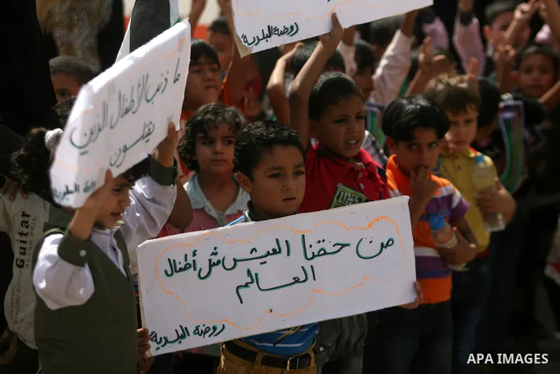 Palestinian children hold banners during a demonstration to calling on Egyptian authorities to open the Rafah crossing in front of the Rafah crossing between Egypt and the southern Gaza Strip on September 29, 2013. Hundr...