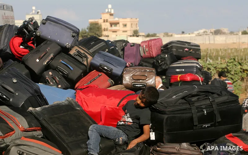A Palestinian passenger, hoping to cross into Egypt, searches for her bag as she waits at the Rafah crossing, between Egypt and the southern Gaza Strip, September 30, 2013. Egypt partially reopened its border crossing wi...