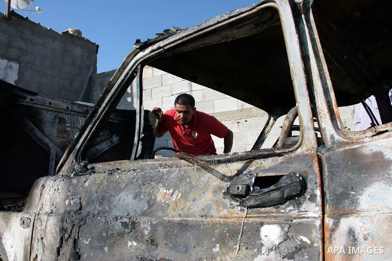 A Palestinian man inspects a burnt car in the village of Burin, near the West Bank City of Nablus, 1 October 2013. According to Palestinians two cars were set on fire in a raid by Jewish settlers. Photo by Nedal Eshtayah