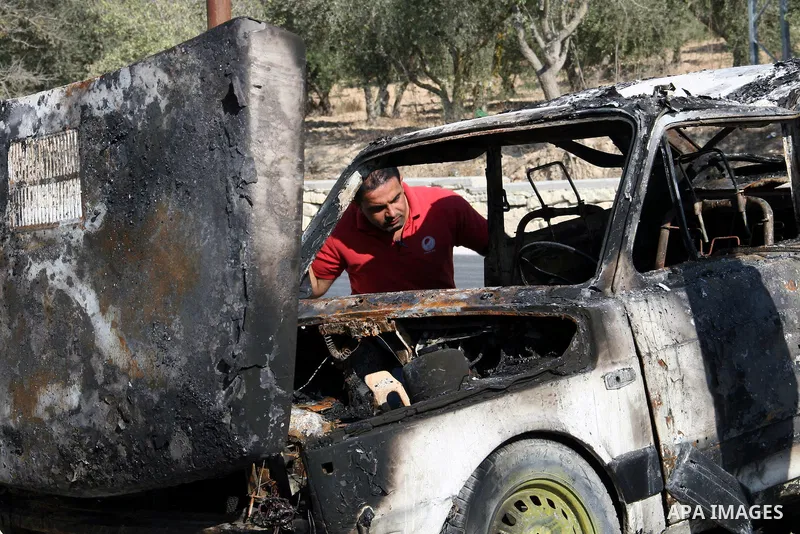 A Palestinian man inspects a burnt car in the village of Burin, near the West Bank City of Nablus, 1 October 2013. According to Palestinians two cars were set on fire in a raid by Jewish settlers. Photo by Nedal Eshtayah
