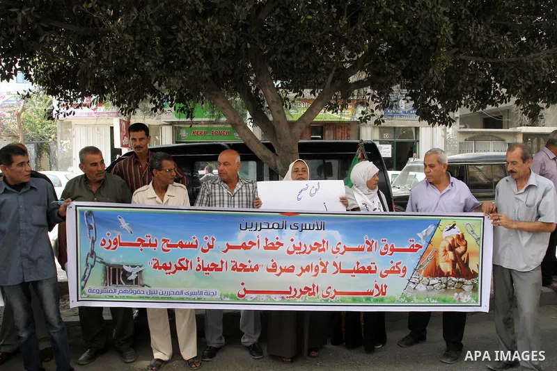 Families of Palestinian prisoners take part in a protest against non-payment the salaries of prisoners in front of the headquarters of the Palestinian Liberation Organization (PLO), in Gaza on Oct. 01, 2013. Photo by Moh...