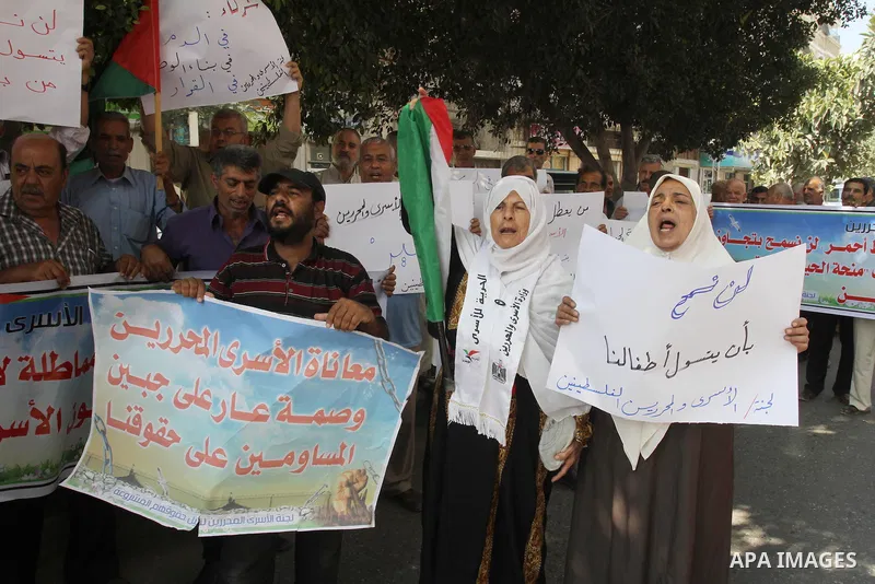 Families of Palestinian prisoners take part in a protest against non-payment the salaries of prisoners in front of the headquarters of the Palestinian Liberation Organization (PLO), in Gaza on Oct. 01, 2013. Photo by Moh...