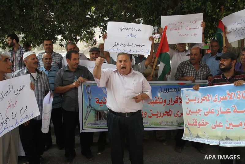 Families of Palestinian prisoners take part in a protest against non-payment the salaries of prisoners in front of the headquarters of the Palestinian Liberation Organization (PLO), in Gaza on Oct. 01, 2013. Photo by Moh...