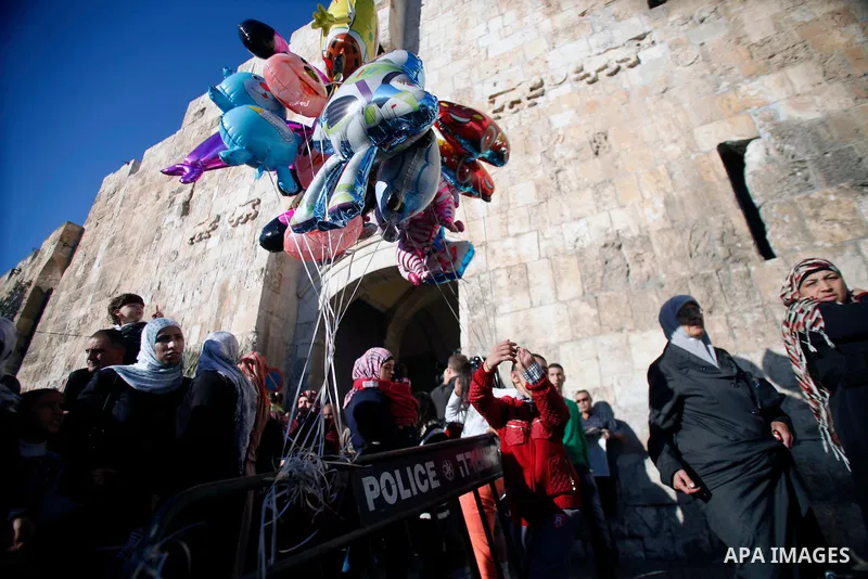 A Palestinian boy sells ballons in front of Damscus gate in Jerusalem s old city following morning prayers on the Muslim holiday of Eid al-Adha or "The Feast of Sacrifice" on October 15, 2013. Muslims across the world ar...