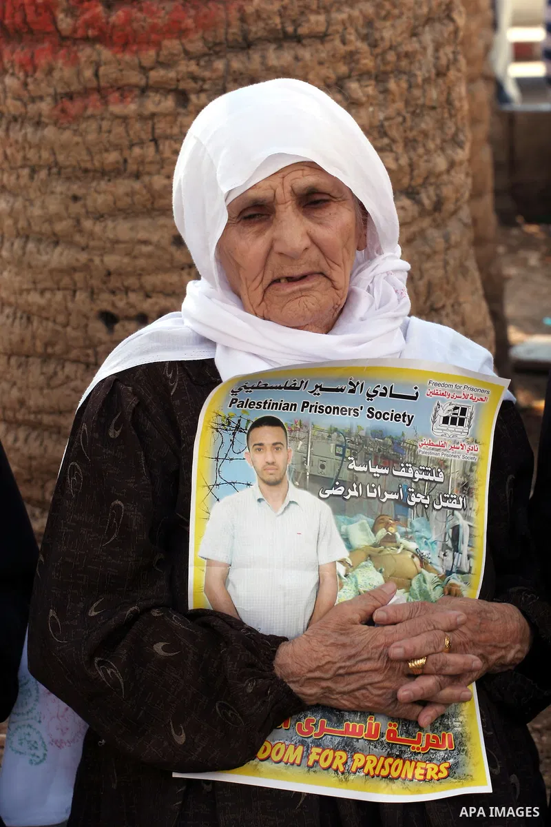 Protesters hold portraits of Hassan al-Turabi, a Palestinian prisoner, during a demonstration in solidarity with prisoners in Israeli jails, in the West Bank City of Nablus, Oct. 20, 2013. The Palestinian Prisoners' Soci...
