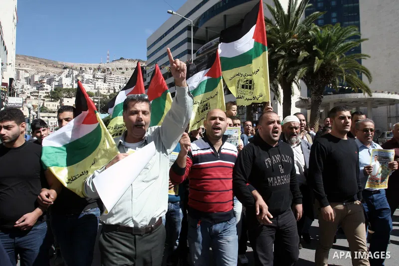 Protesters hold portraits of Hassan al-Turabi, a Palestinian prisoner, during a demonstration in solidarity with prisoners in Israeli jails, in the West Bank City of Nablus, Oct. 20, 2013. The Palestinian Prisoners' Soci...