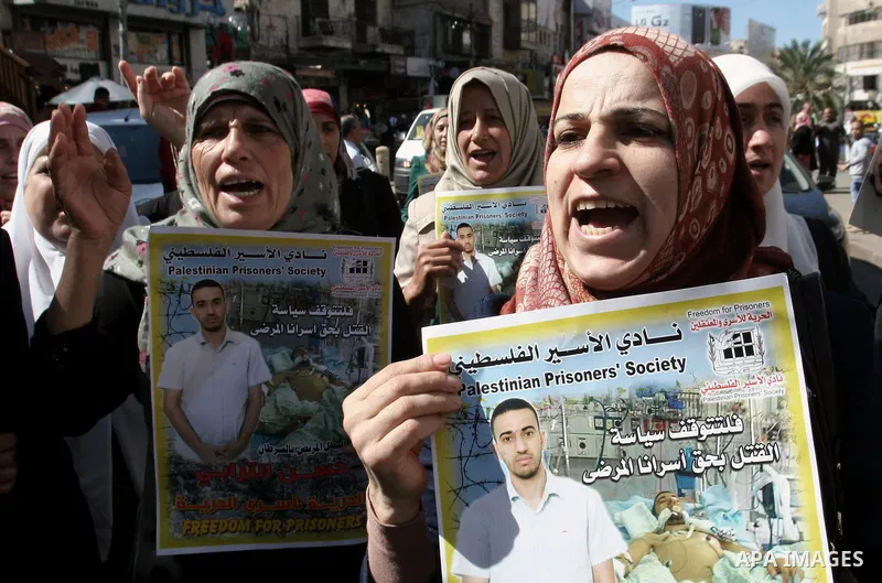 Protesters hold portraits of Hassan al-Turabi, a Palestinian prisoner, during a demonstration in solidarity with prisoners in Israeli jails, in the West Bank City of Nablus, Oct. 20, 2013. The Palestinian Prisoners' Soci...