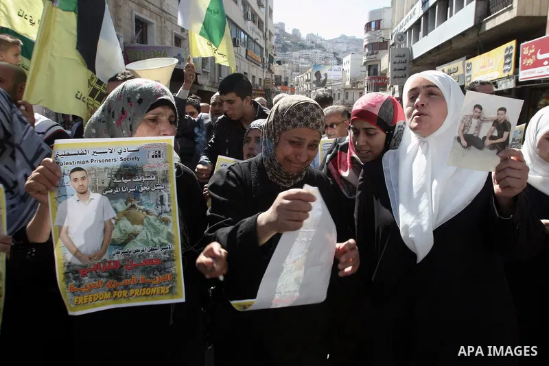 Protesters hold portraits of Hassan al-Turabi, a Palestinian prisoner, during a demonstration in solidarity with prisoners in Israeli jails, in the West Bank City of Nablus, Oct. 20, 2013. The Palestinian Prisoners' Soci...