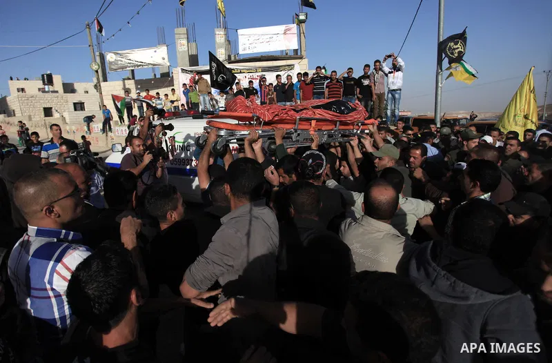 Palestinian mourners carry the body of Younis al-Radaideh during his funeral in Ubiedyeh village near the West Bank city of Bethlehem, Oct. 21, 2013. Israeli forces on Thursday shot and killed Younis Ahmed Radaideh, 28,...