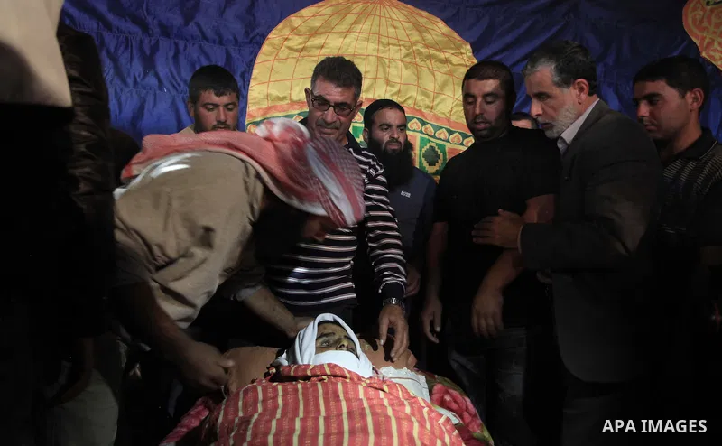 Palestinian relatives of Younis al-Radaideh mourn over his body during his funeral in Ubiedyeh village near the West Bank city of Bethlehem, Oct. 21, 2013. Israeli forces on Thursday shot and killed Younis Ahmed Radaideh...
