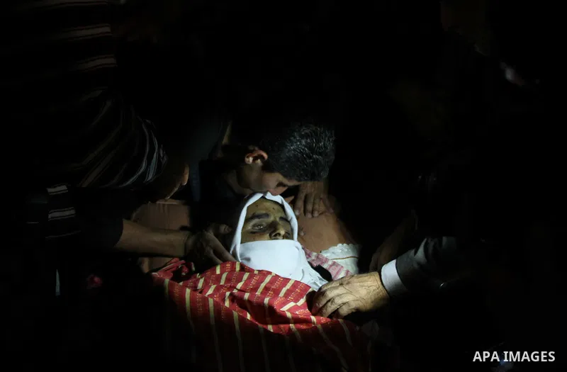 Palestinian relatives of Younis al-Radaideh mourn over his body during his funeral in Ubiedyeh village near the West Bank city of Bethlehem, Oct. 21, 2013. Israeli forces on Thursday shot and killed Younis Ahmed Radaideh...