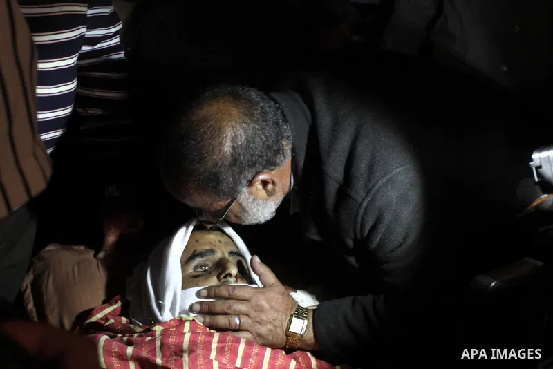 Palestinian relatives of Younis al-Radaideh mourn over his body during his funeral in Ubiedyeh village near the West Bank city of Bethlehem, Oct. 21, 2013. Israeli forces on Thursday shot and killed Younis Ahmed Radaideh...