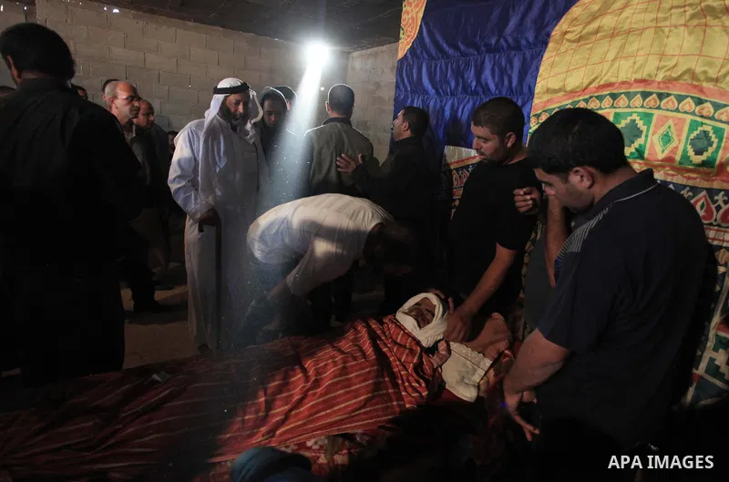 Palestinian relatives of Younis al-Radaideh mourn over his body during his funeral in Ubiedyeh village near the West Bank city of Bethlehem, Oct. 21, 2013. Israeli forces on Thursday shot and killed Younis Ahmed Radaideh...