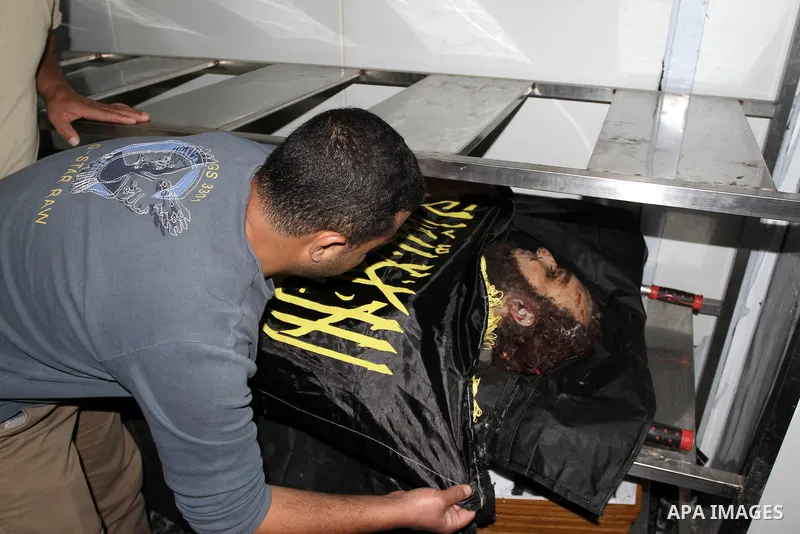A relative stands next to the body of Palestinian Islamic Jihad militant Mohammed Assi, at a hospital in the West Bank city of Ramallah, Tuesday, Oct. 22, 2013. Israel's security service and the military said Israeli for...