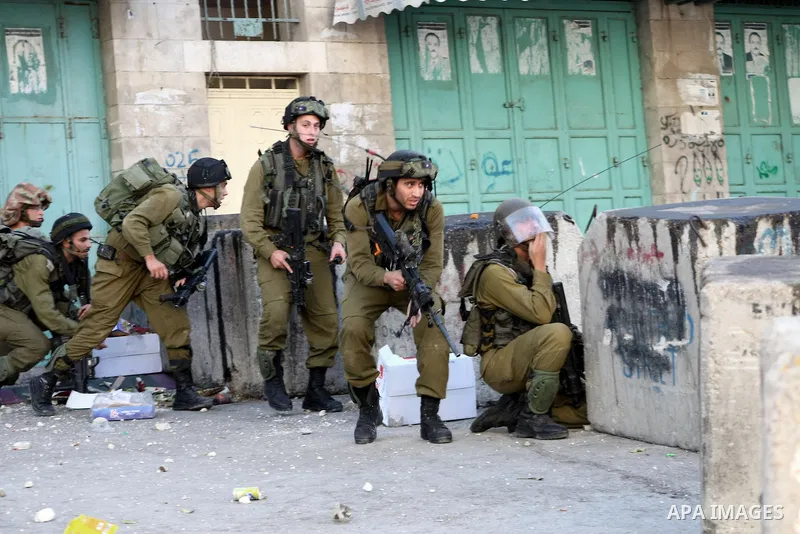 Israeli soldiers take position during clashes with Palestinian youths in the West Bank city of Hebron, after killing of Palestinian Islamic Jihad militant Mohamed Assi in Bilin near Ramallah, Tuesday, Oct. 22, 2013. Isra...