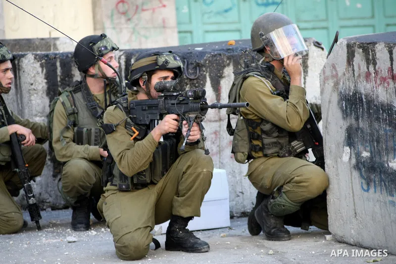 Israeli soldiers take position during clashes with Palestinian youths in the West Bank city of Hebron, after killing of Palestinian Islamic Jihad militant Mohamed Assi in Bilin near Ramallah, Tuesday, Oct. 22, 2013. Isra...