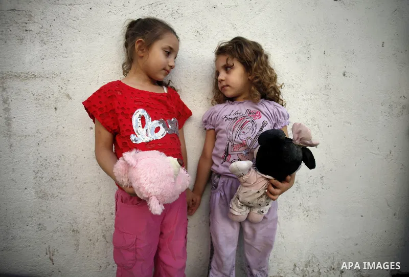 The daughters of Khaled al-Zeer al-Husaini, 39, stand outside their father's cave in the east Jerusalem Arab neighbourhood of Silwan, Oct. 22, 2013. An Israeli court demanded family Silwan to stop the restoration work in...