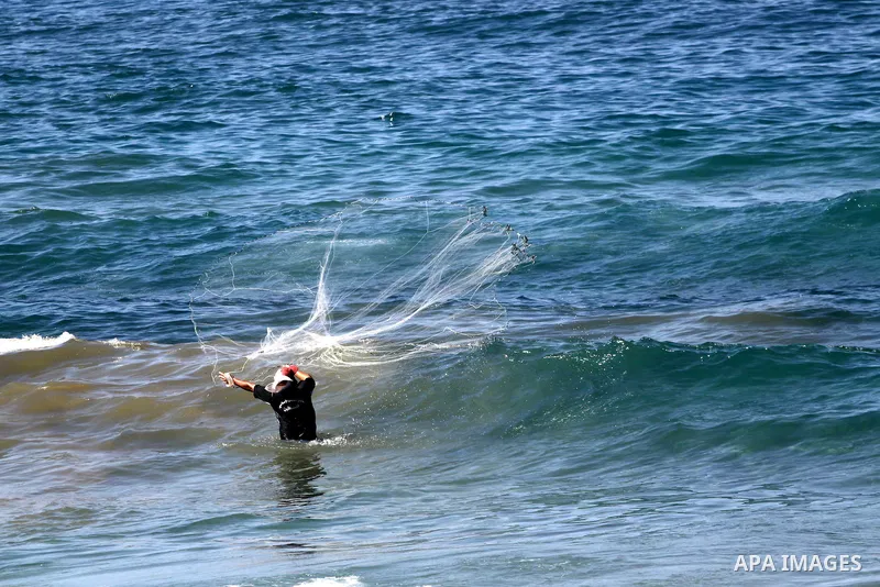 A Palestinian fisherman throws his net into the sea at the beach of Gaza City, on Oct. 23, 2013. Israel restricted the fishing zone to three nautical miles following the kidnapping of Israeli soldier Gilad Shalit in 2007...