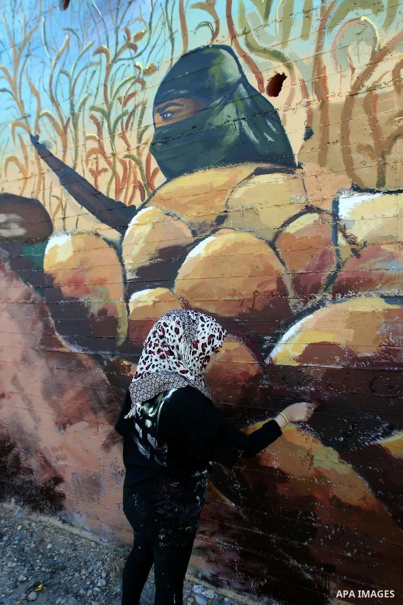 A Palestinian artist paints a mural depicting Palestinian heritage, in the West Bank city of Nablus, on Oct. 24, 2013. Photo by Nedal Eshtayah