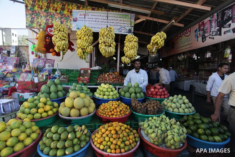 A Palestinian man sells fruits at his shop in a market in Gaza City on Oct. 27, 2013. Photo by Ashraf Amra