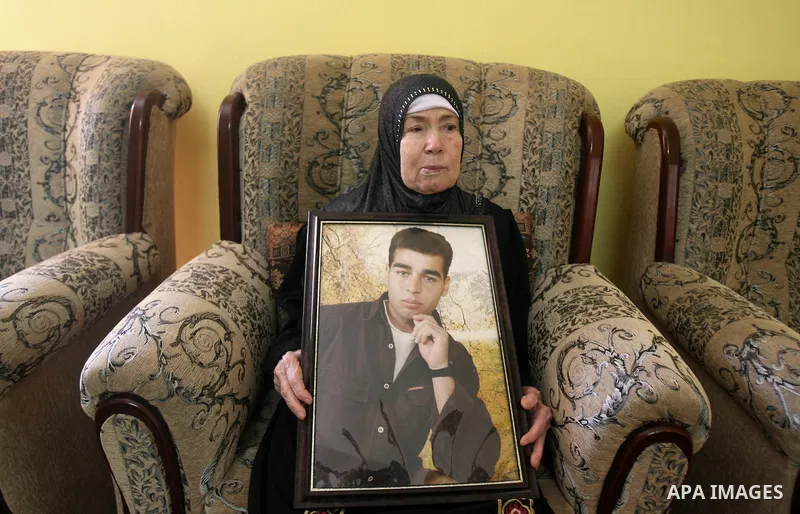 The mother of Palestinian prisoner Hazem Shubair, who has been held by Israel since 1994, holds his picture after hearing news on his expected release, in Khan Younis in the southern Gaza Strip October 28, 2013. Israelis...