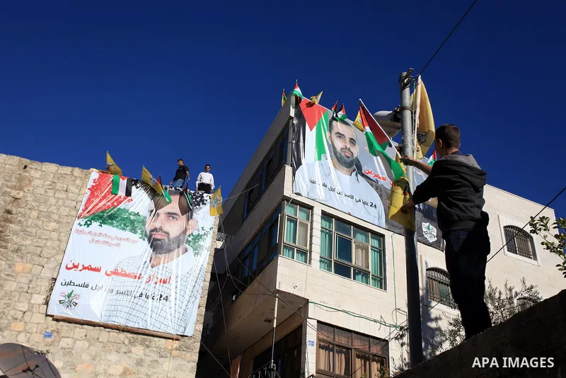 Relatives hang a banner depicting Palestinian prisoner Israr Samreen outside his house, in the West Bank city of Ramallah October 28, 2013. Samreen is one of 26 Palestinian prisoners that Israel approved on Sunday to rel...