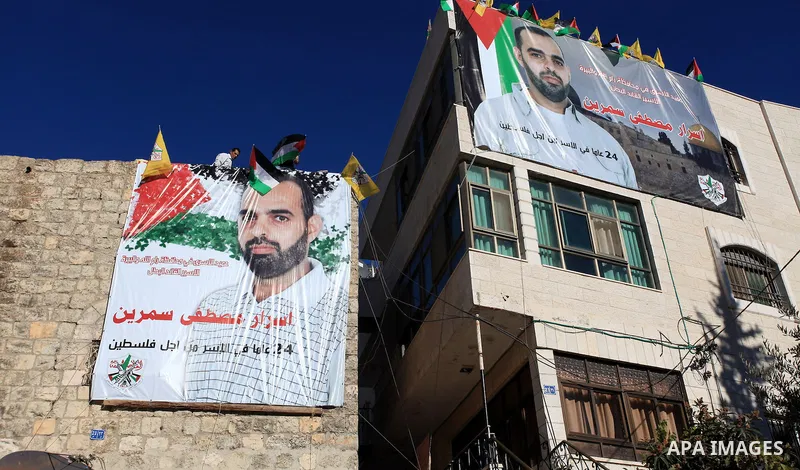 Relatives hang a banner depicting Palestinian prisoner Israr Samreen outside his house, in the West Bank city of Ramallah October 28, 2013. Samreen is one of 26 Palestinian prisoners that Israel approved on Sunday to rel...