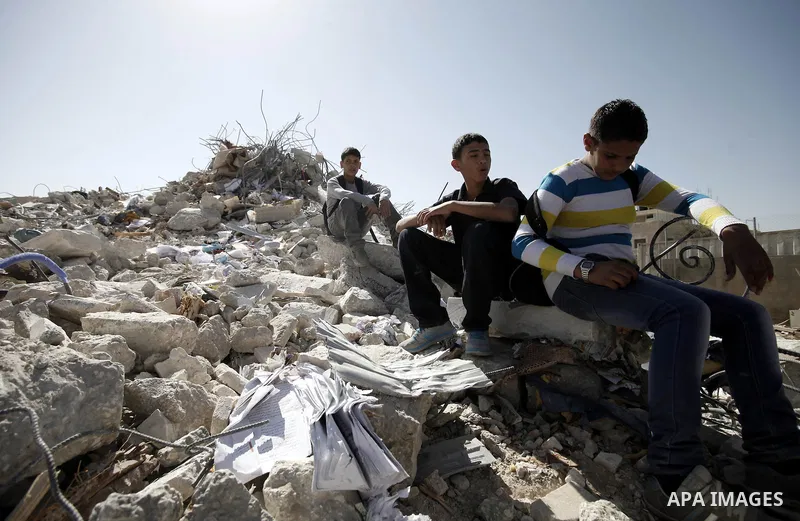 Palestinian boys search in the remains of a house after demolished by Jerusalem Municipality in the East Jerusalem neighbourhood of Beit Hanina, October 29, 2013. A statement from the Jerusalem Municipality said there wa...