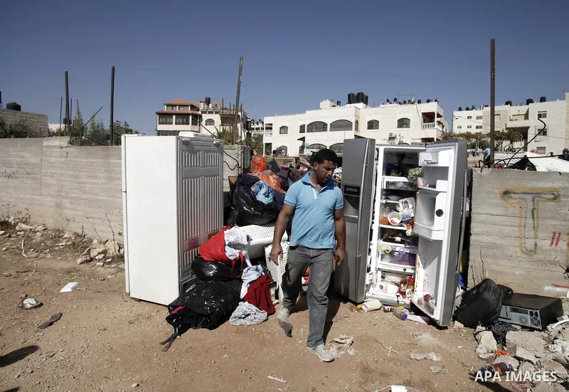 A Palestinian man walks past the personal belongings of a Palestinian family after their house was demolished by Israeli municipality in the East Jerusalem neighbourhood of Beit Hanina, October 29, 2013. A statement from...