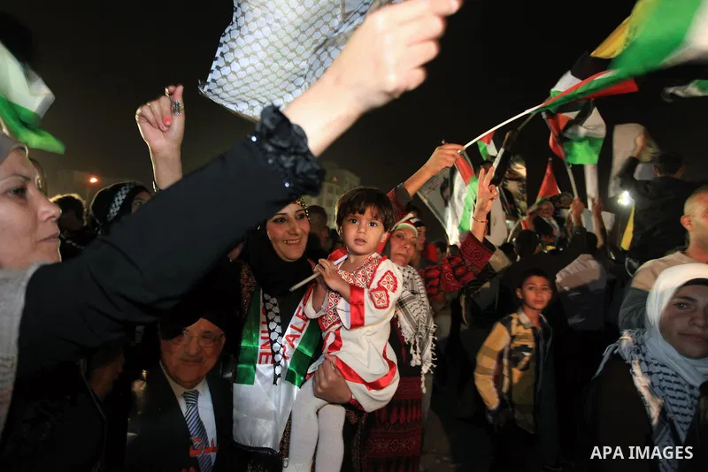 Palestinian families and friends celebrate as they gather outside the headquarters of president Mahmud Abbas for the release of some 26 prisoners from Israeli jails, in the West Bank city of Ramallah, on October 29, 2013...