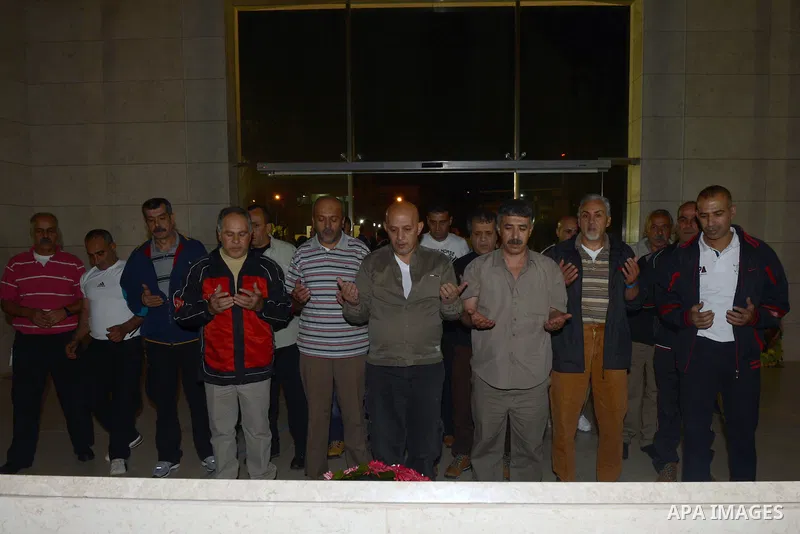 Released Palestinian prisoners pray over the grave of former Palestinian leader Yasser Arafat upon their arrival at the headquarters of Palestinian President Mahmoud Abbas in the West Bank city of Ramallah, October 30, 2...