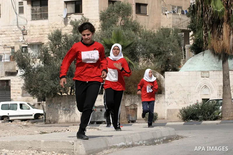 Palestinian girls run during students' marathon in the West Bank City of Nablus, October 31, 2013. Hundreds of school girls from 10 to 15 years participated in the marathon organised by the directorate of education in Na...