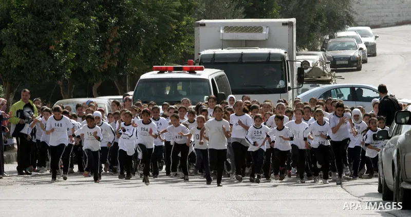 Palestinian girls run during students' marathon in the West Bank City of Nablus, October 31, 2013. Hundreds of school girls from 10 to 15 years participated in the marathon organised by the directorate of education in Na...
