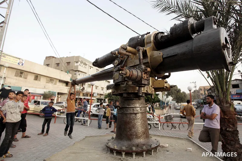 A Palestinian boy play on an old canon that was found by Palestinian fishermen in the waters of the Mediterranean Sea in front of the Gaza Strip coast, at the main square in Deir al-Balah, central Gaza Strip, Thursday, O...
