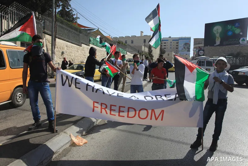 Palestinian protesters hold flags and a banner during a demonstration against the visit of the US Secretary of State John Kerry and peace negotiations, in the West Bank city of Bethlehem, 06 November 2013. Kerry began a...