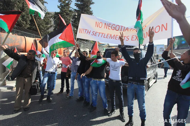 Palestinian protesters hold flags and a banner during a demonstration against the visit of the US Secretary of State John Kerry and peace negotiations, in the West Bank city of Bethlehem, 06 November 2013. Kerry began a...