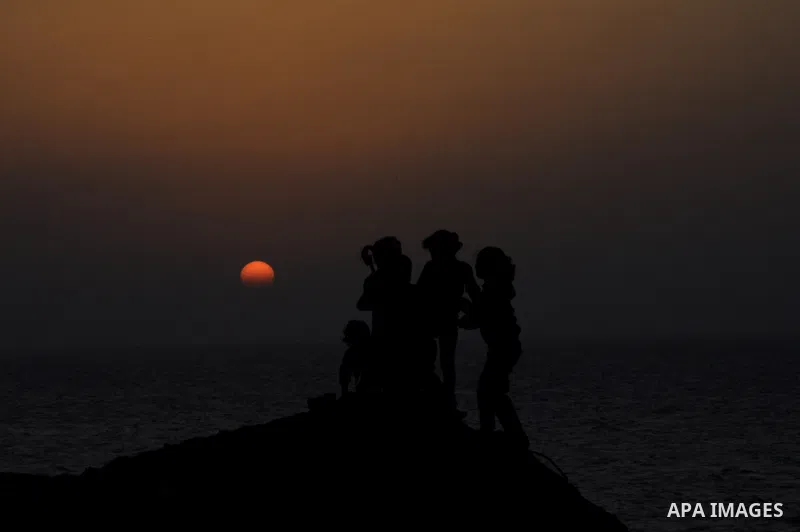 Palestinian children play outside their house during sunset at Al-Shatea' refugee camp in Gaza City on November 8, 2013. Gaza's lone power plant shut its generators on Friday due to a fuel shortage, a move that will like...