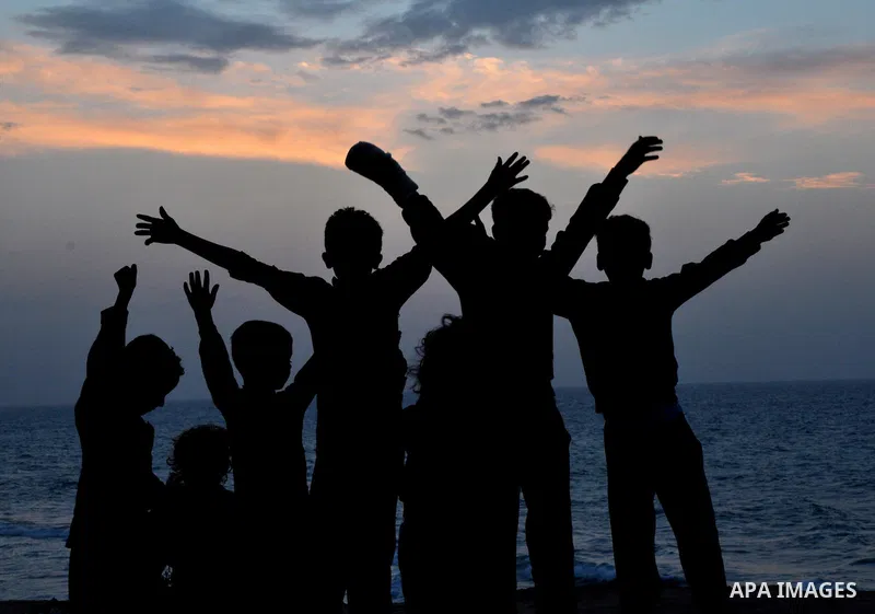 Palestinian children play outside their house during sunset at Al-Shatea' refugee camp in Gaza City on November 8, 2013. Gaza's lone power plant shut its generators on Friday due to a fuel shortage, a move that will like...